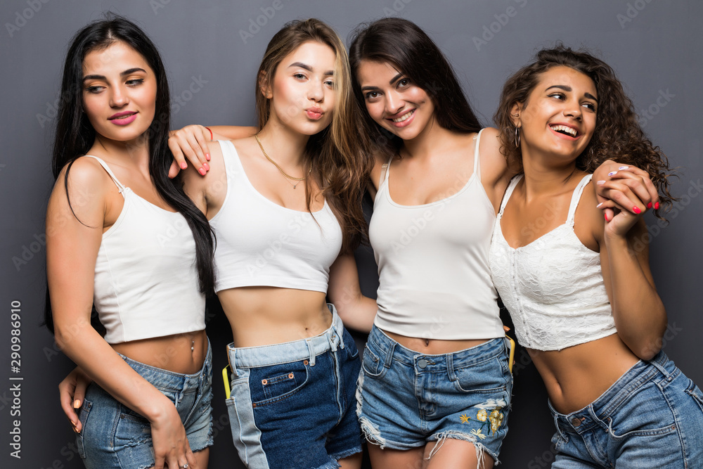 Young pretty girls standing on the gray background Young pretty girls standing on the gray background