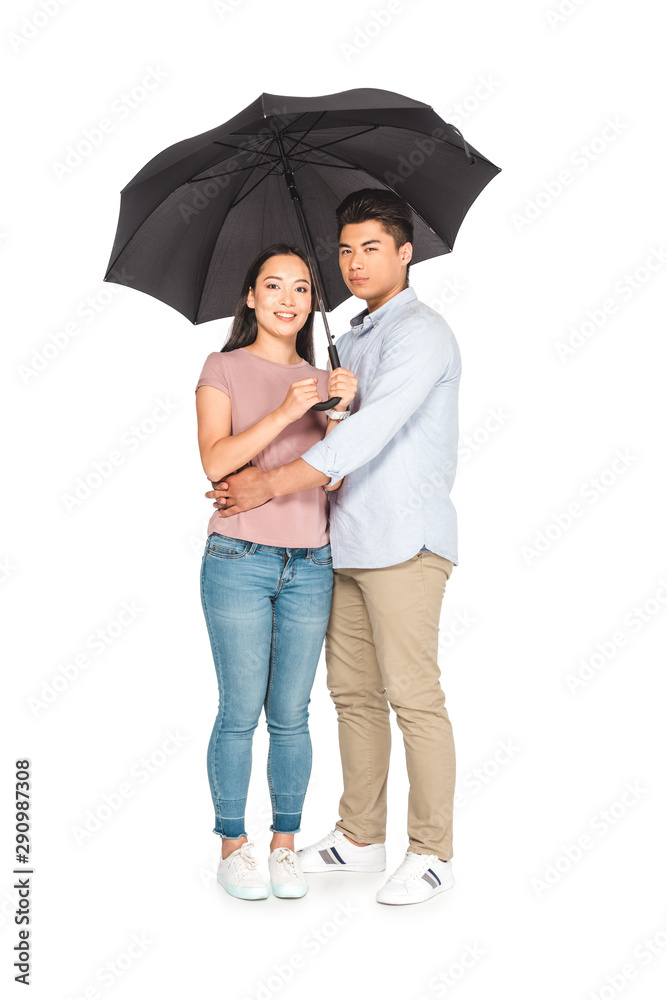 young asian man hugging girlfriend while standing under umbrella together on white background young asian man hugging girlfriend while standing under umbrella together on white background