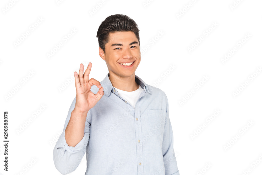 happy asian man showing okay sign while smiling at camera isolated on white happy asian man showing okay sign while smiling at camera isolated on white