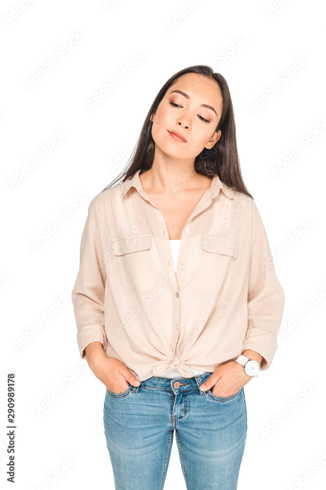 thoughtful asian woman holding hands in pockets while posing at camera isolated on white thoughtful asian woman holding hands in pockets while posing at camera isolated on white