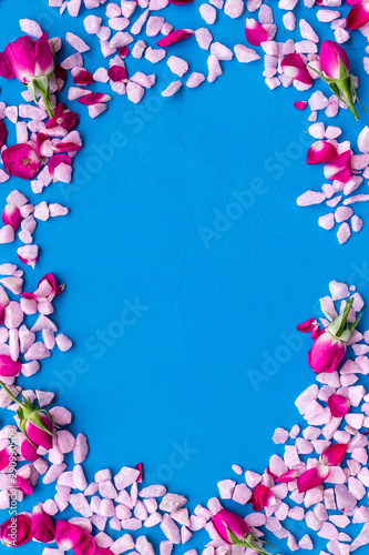 decorative pebble and roses frame for design on blue background top view mock-up