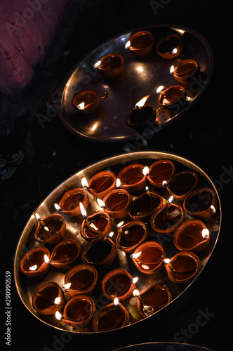 A plate is which is loaded with rose and candle on indian festival diwali deepawali with fire isolated on table