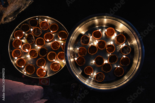 A plate is which is loaded with rose and candle on indian festival diwali deepawali with fire isolated on table
