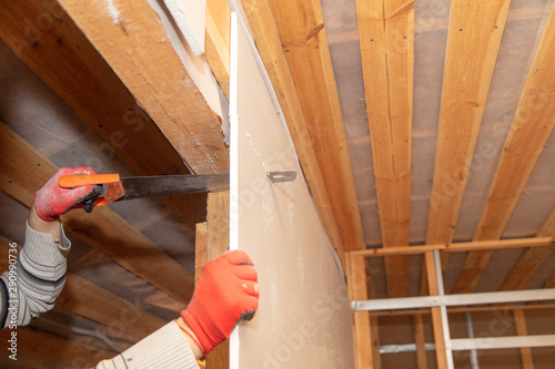 A worker cuts drywall at a construction site photo