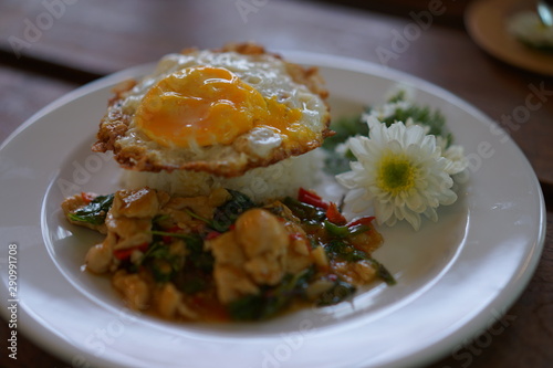 Rice topped with stir-fried pork and basil with fire egg And decorate the dish with white flowers