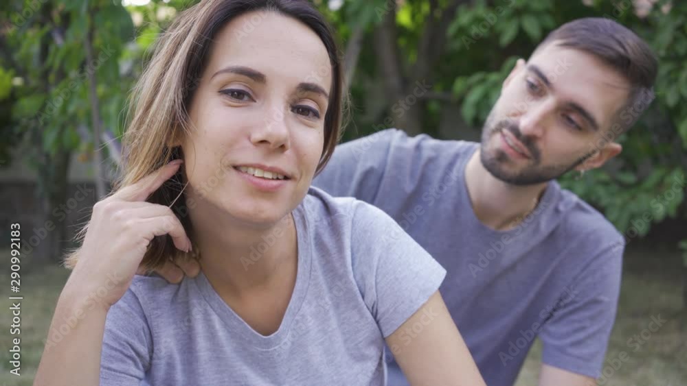 Portrait of young family sitting in the summer garden. Happy young family resting outdoors. Concept of happiness, relationship, tenderness