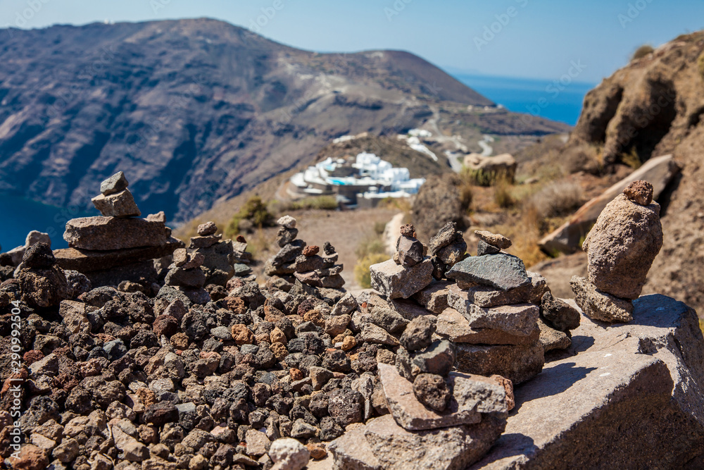 Cairns of rocks at the walking path number 9 between the cities of Fira and Oia at Santorini Island