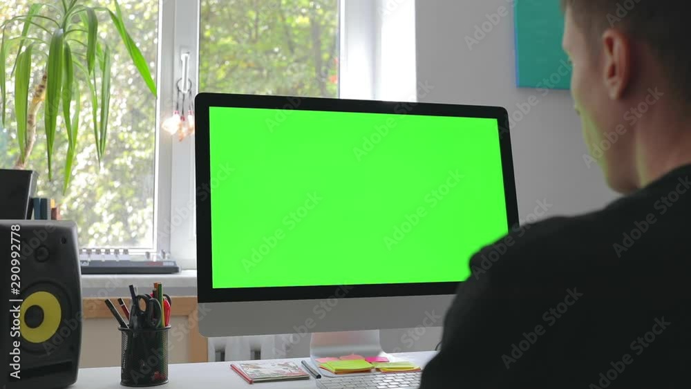 Smart man working at home in loft room on personal computer with green screen and chroma key writing programming code for new business 5g platform freelance