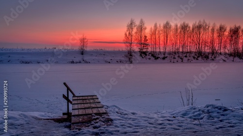 Winter blue hour with the pier and frozen river after sunset photo