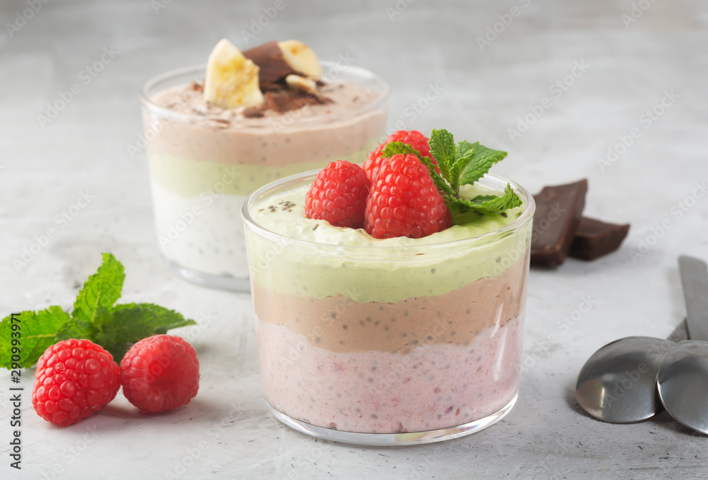 Chia seed pudding with three flavors, cocoa, matcha and strawberry with yoghurt, chocolate and mint leaves, horizontal orientation Chia seed pudding with three flavors, cocoa, matcha and strawberry with yoghurt, chocolate and mint leaves, horizontal orientation