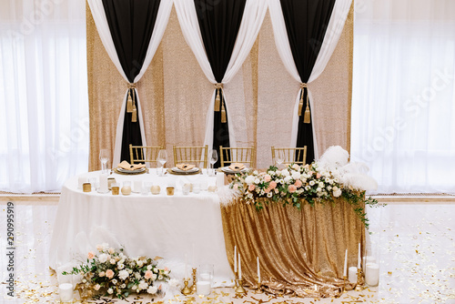 Compact stylish wedding presidium on a luxurious background in the white hall of the restaurant photo