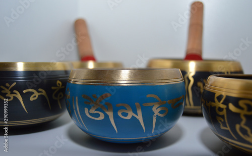 Ornate black and blue tibetan bowls with golden symbols used for massage therapy