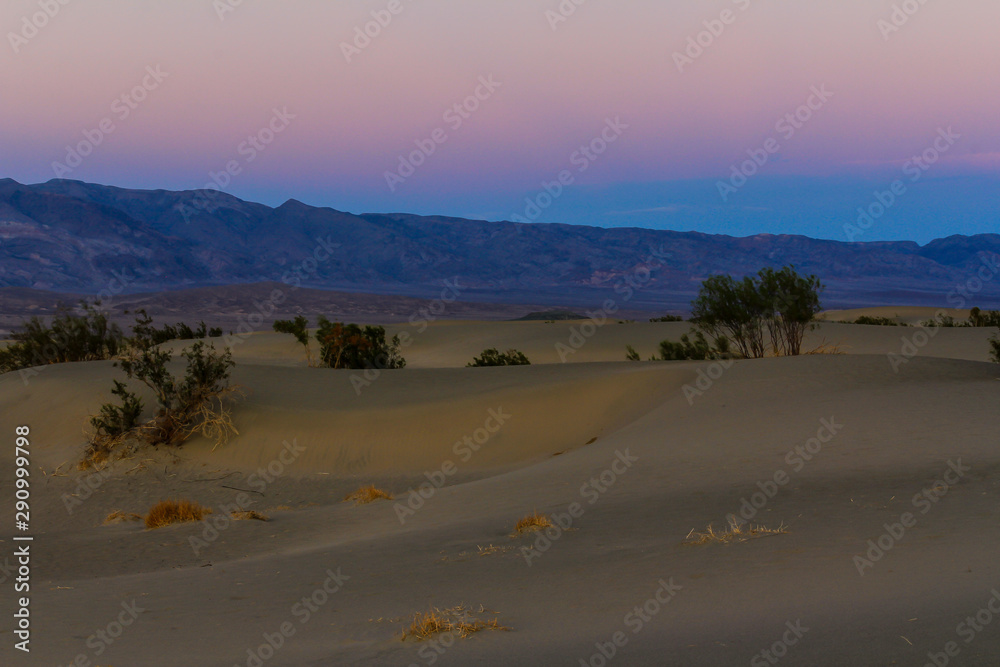 Looking Across Sand Dunes of Death Valley at Sun Setting behind Sierra Nevada Mountains Looking Across Sand Dunes of Death Valley at Sun Setting behind Sierra Nevada Mountains