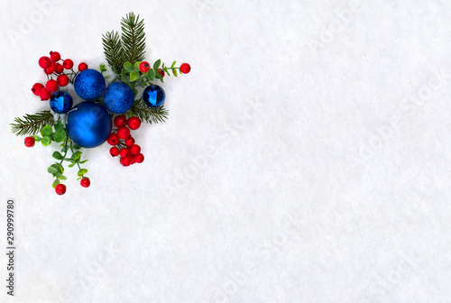 Christmas decoration. Twigs christmas tree, christmas blue balls and red berries on snow with space for text. Top view, flat lay