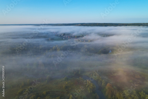 Aerial photography from the drone. Village in the woods in the morning fog