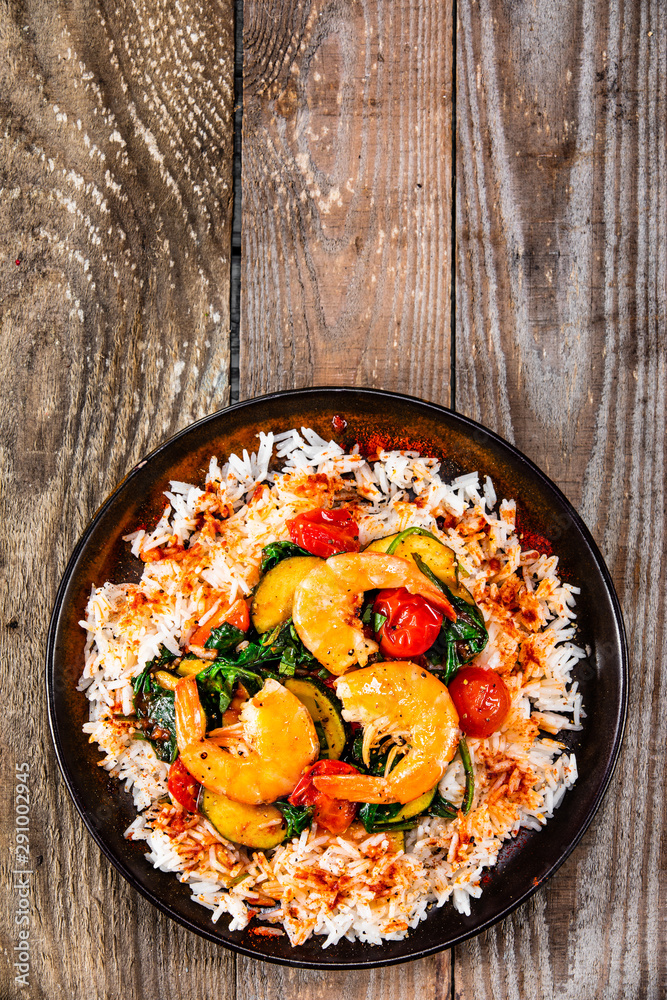 Shrimps with white rice and vegetables on wooden table Shrimps with white rice and vegetables on wooden table