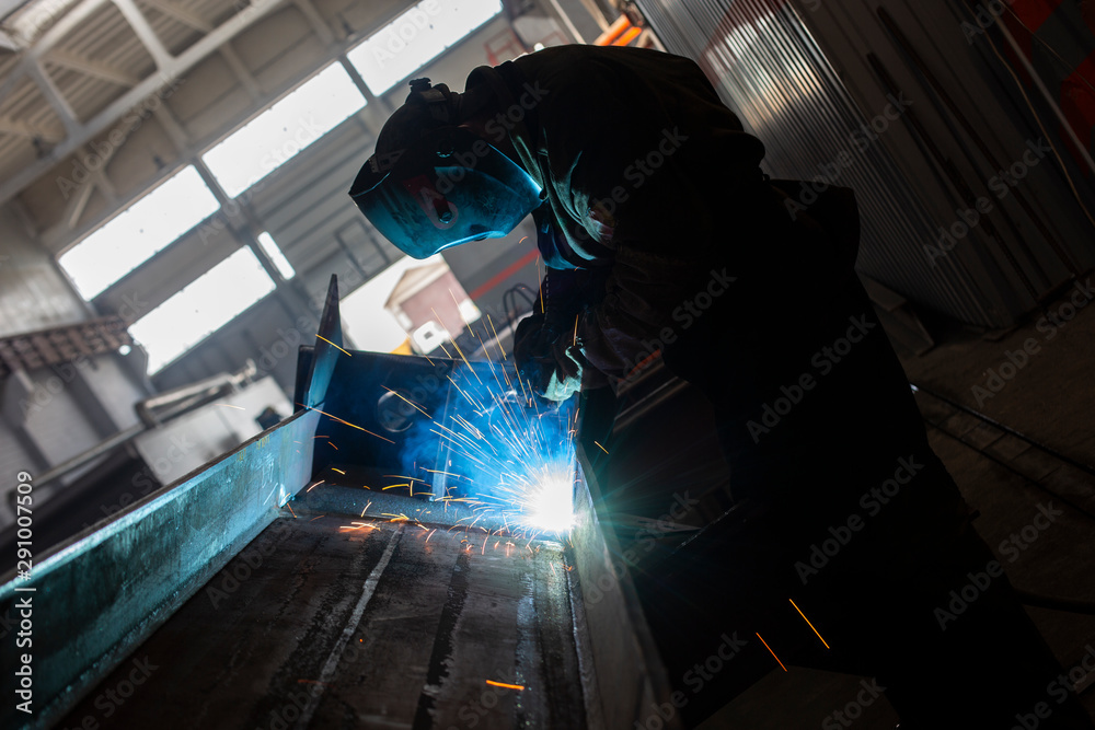 Industrial Worker at the factory welding closeup in glasses sparks Industrial Worker at the factory welding closeup in glasses sparks
