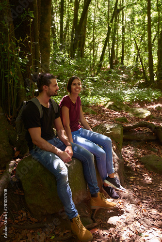 Man and woman sitting resting on a large rock