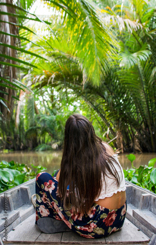 Imagen de una joven mujer paseando en canoa por el Delta del Mekong en Vietnam durante el verano