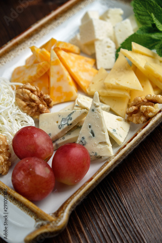 Cheese platter on a dark background. Food styling. Restaurant menu