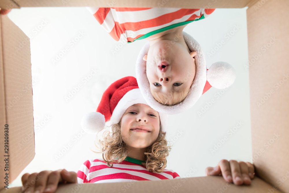 Surprised children unpack Christmas gift box Surprised children unpack Christmas gift box