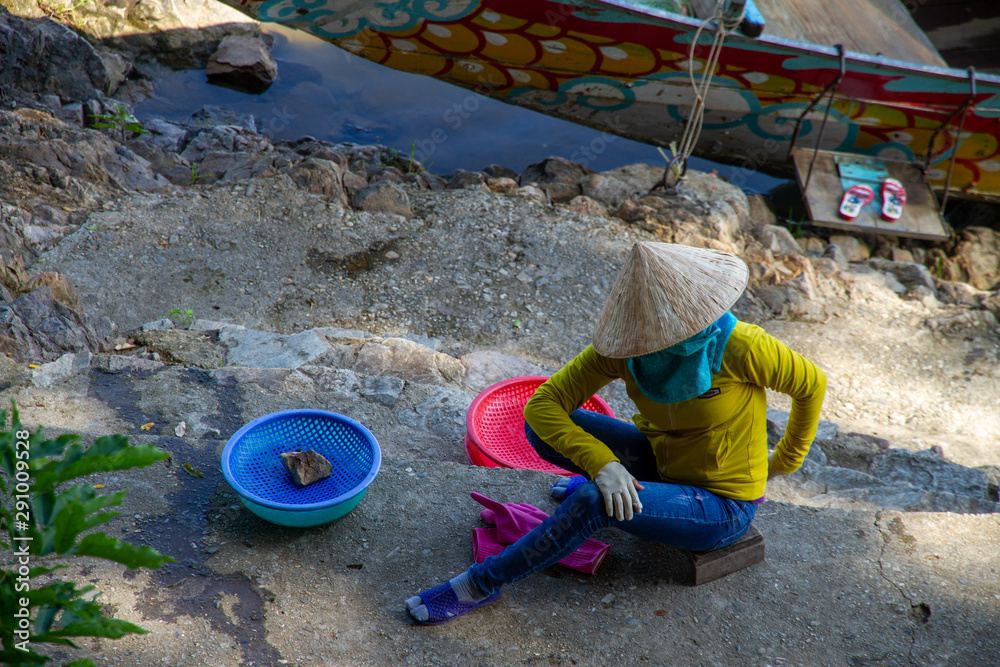 Woman selling fish while on cellphone, Vietnam Woman selling fish while on cellphone, Vietnam