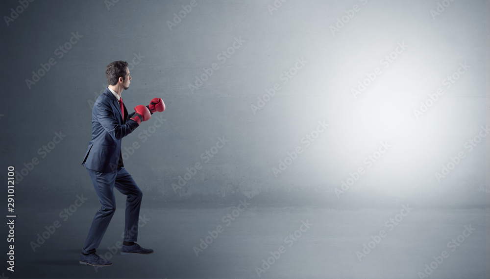 Businessman fighting with boxing gloves in an empty space Businessman fighting with boxing gloves in an empty space