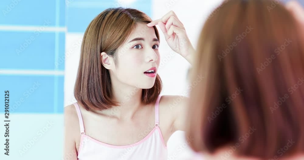 woman check wrinkles on forehead woman check wrinkles on forehead
