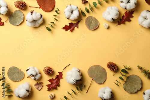 Flat lay composition with cotton flowers on yellow background. Space for text