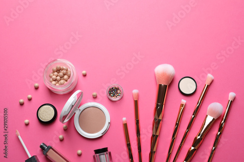 Flat lay composition with makeup brushes on pink background. Space for text