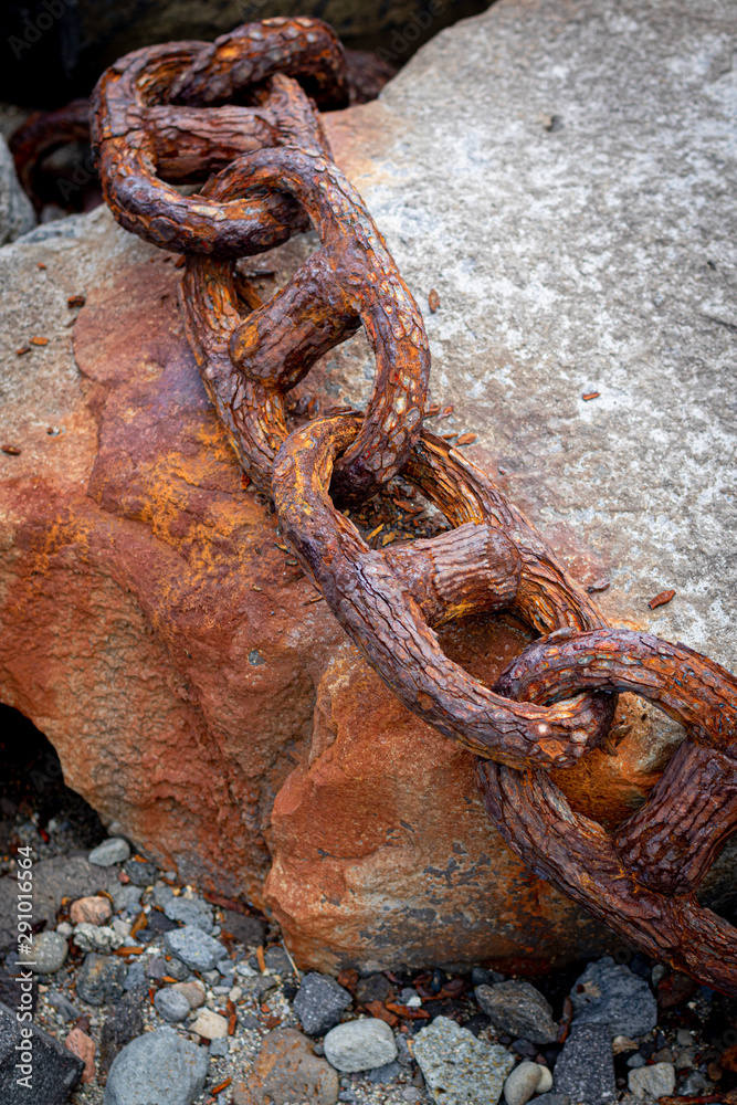 Rusty links of giant chain on stone Rusty links of giant chain on stone