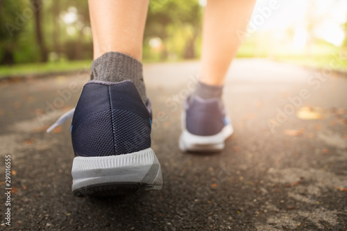 Female jogging in Central Park by wearing sports shoes. photo