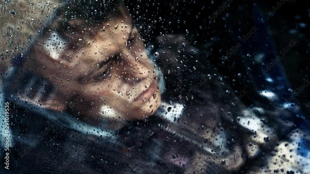 Sad man behind glass of car in rain Sad man behind glass of car in rain
