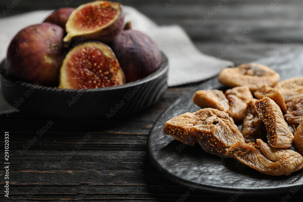 Slate plate with tasty dried figs on black wooden table, closeup. Space for text Slate plate with tasty dried figs on black wooden table, closeup. Space for text
