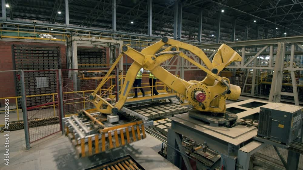 Two men, engineers, technicians, colleagues check a working machine at a plant.