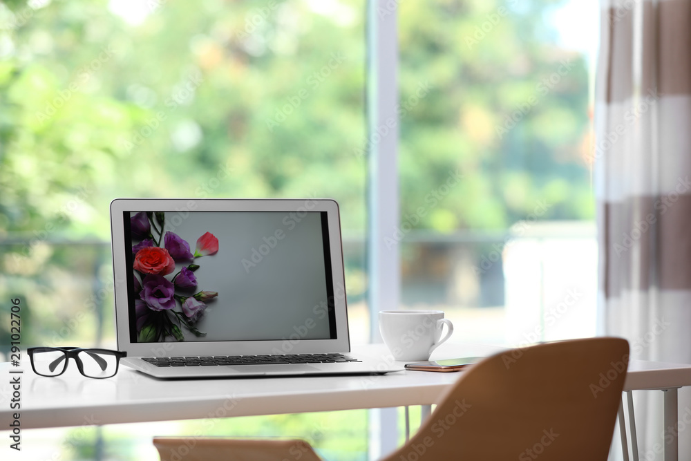 Comfortable workplace with modern laptop on desk in home office, space for text Comfortable workplace with modern laptop on desk in home office, space for text