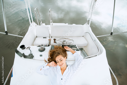 Pretty women lying on yacht deck and enjoying relaxing in sea travel photo