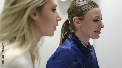 Female doctor shows the patient an x-ray image at display. Computer diagnostics dental tomography. Planning teeth treatment in modern dental clinic photo