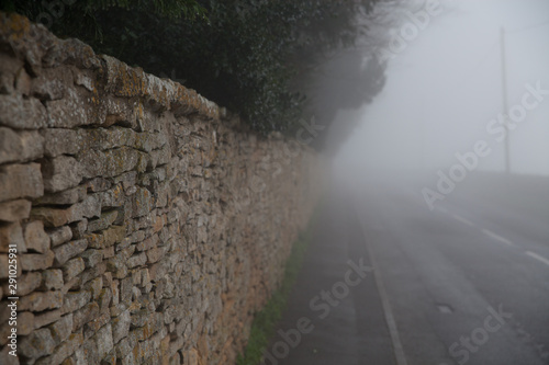 macro dry stone wall in Oxfordshire during foggy weather by a road photo