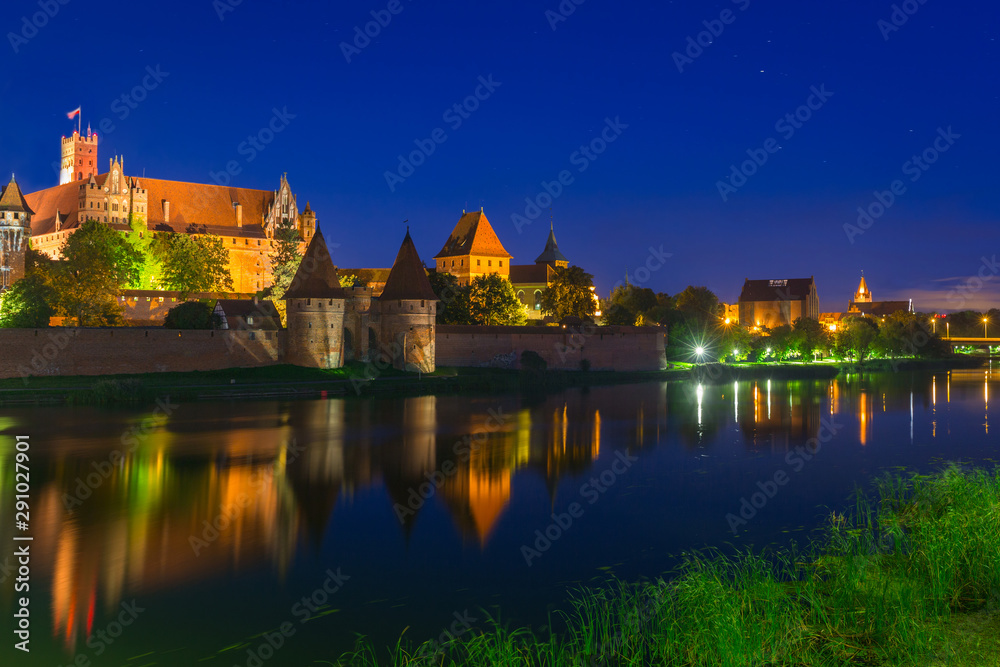 Malbork castle over the Nogat river at night, Poland