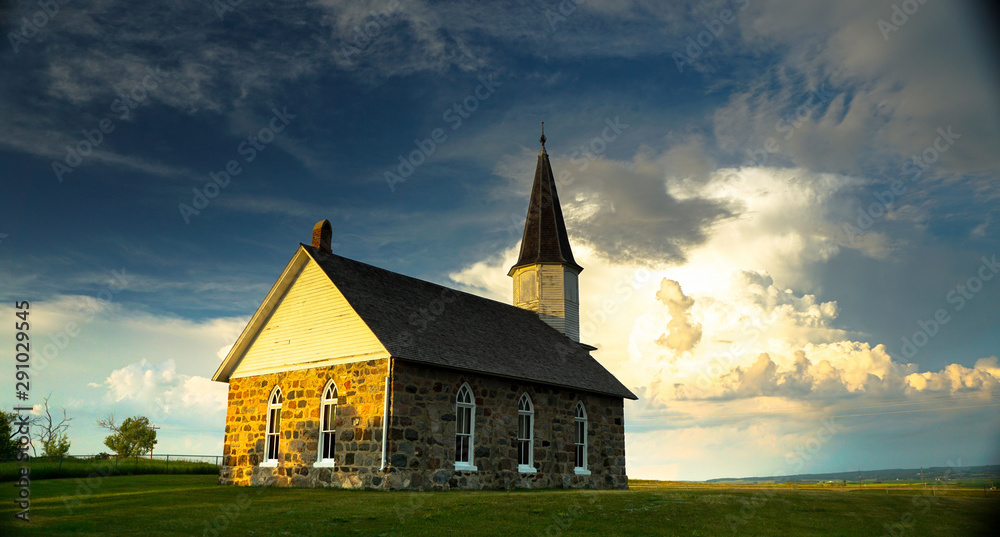 Φωτογραφία Old stone Prairie Church with storm clouds behind it