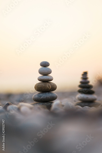 Balanced stone pyramid on pabbles beach with sunset. Zen rock  concept of balance and harmony.