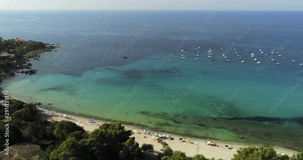 Aerial overhead shot of Sardinia's beach with a clear tourquoise sea, bathers, coloured umbrellas and tourists. Heaven on Earth. Torre delle Stelle. Aerial overhead shot of Sardinia's beach with a clear tourquoise sea, bathers, coloured umbrellas and tourists. Heaven on Earth. Torre delle Stelle.