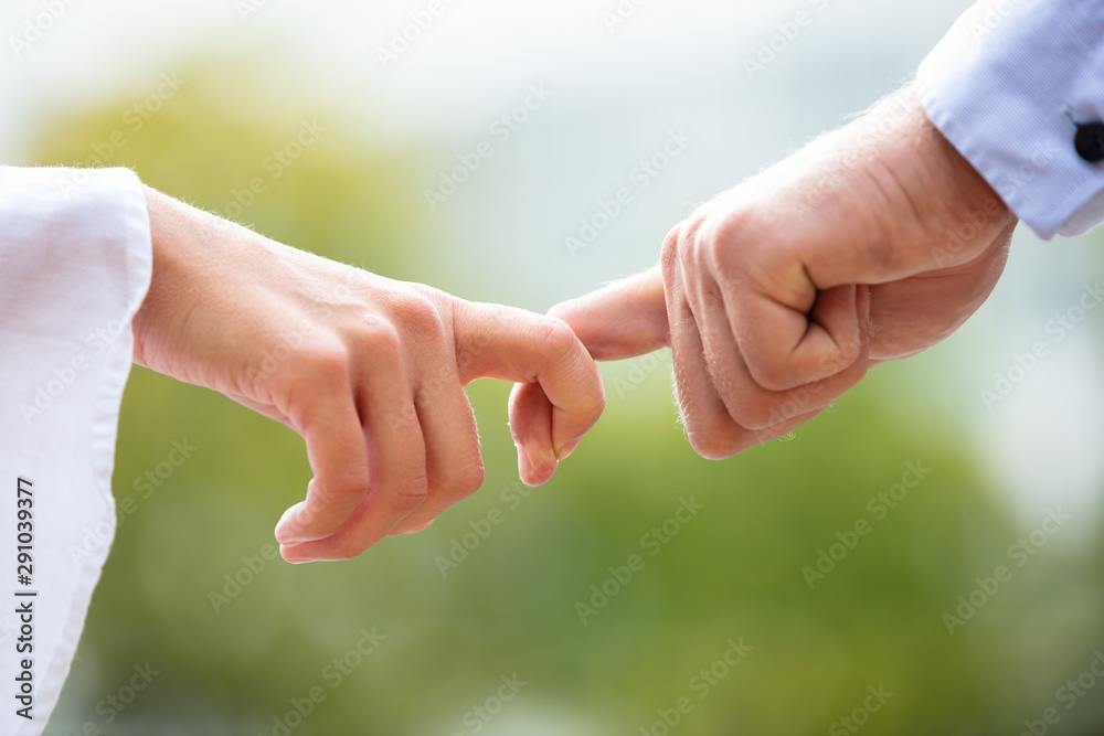 Close-up Of Couple Holding Index Fingers