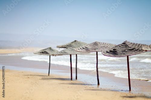 Straw parasols on a deserted sandy beach