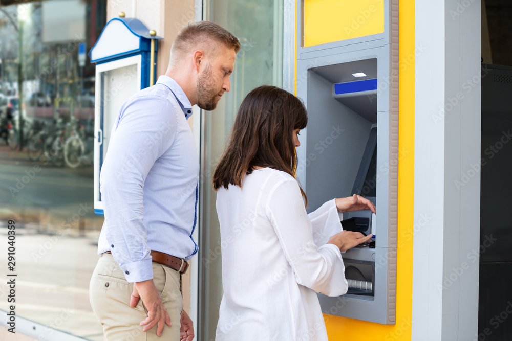 Man Spying For PIN Code While Woman Using An ATM Man Spying For PIN Code While Woman Using An ATM