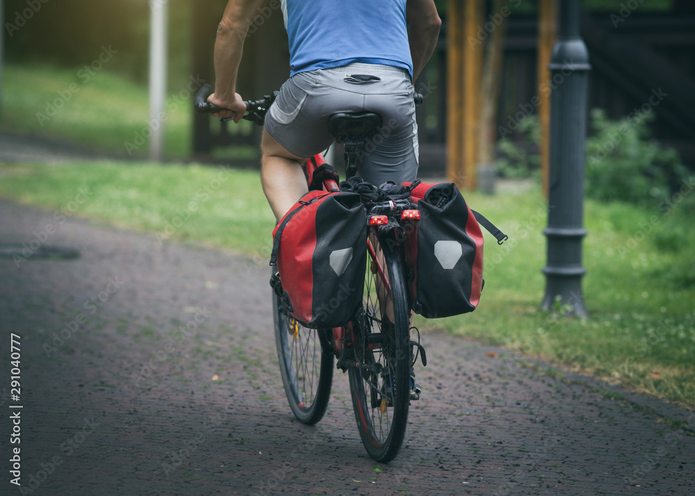 Fototapeta premium Man riding bike with rear seat bags
