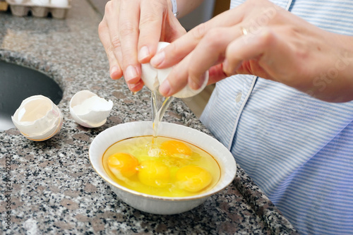 White eggs and woman hand preparation in kitchen