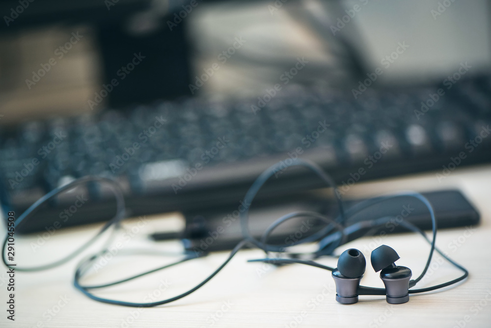 Office desk table with computer, smartphone and headphones. Essential items black color on light desk. Workplace concept Office desk table with computer, smartphone and headphones. Essential items black color on light desk. Workplace concept