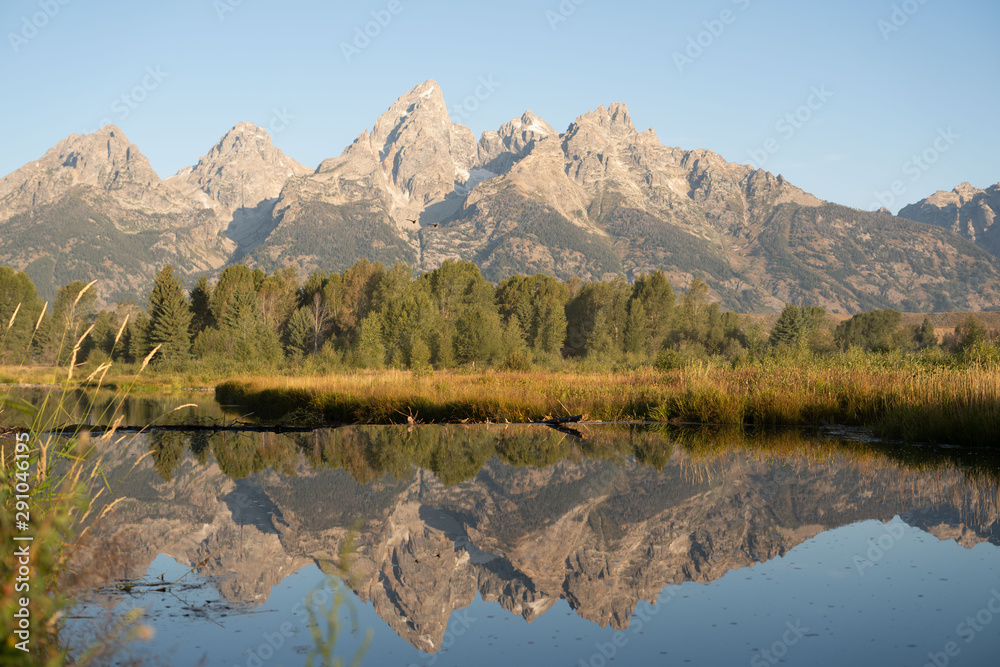 Obraz premium Rocky peaks of the Grand Tetons reflected in the river